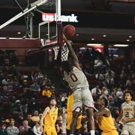 An American team basketball player shoots in a full stadium. 
