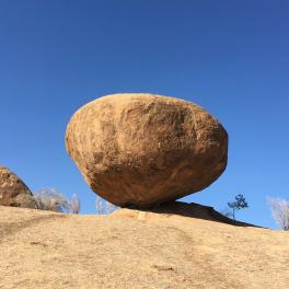 A desert rock with a blue sky behind it. 