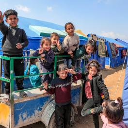 Children smiling at a camp in Gaza.