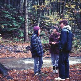 Three young people on a hike in the woods.