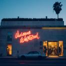 the outside of a shop with a neon sign that reads "vivienne westwood"