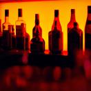 a photo of liquor bottles in red lighting