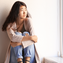 Girl sitting on the floor looking out the window