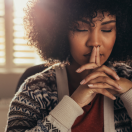 woman sitting with her eyes closed thinking