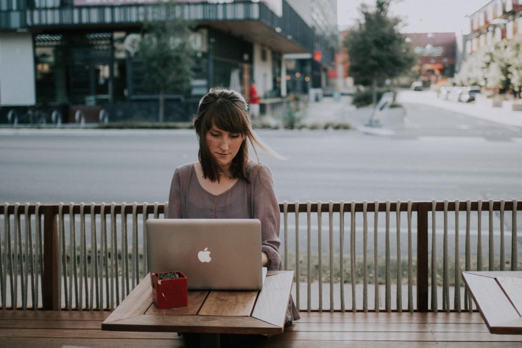 woman sitting at a table working on her laptop