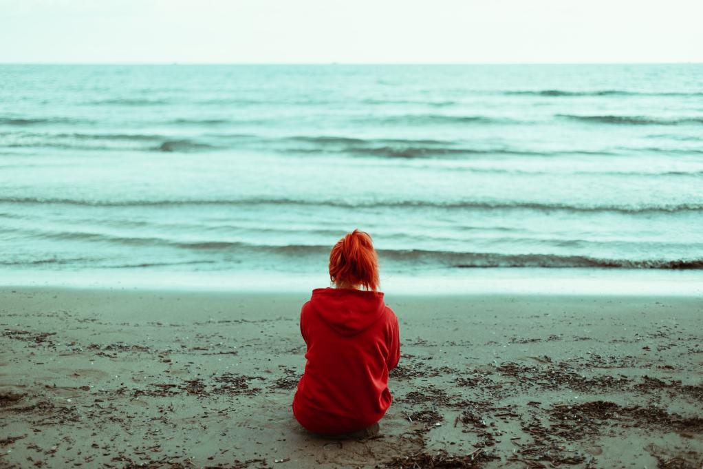 young  person sitting on the beach