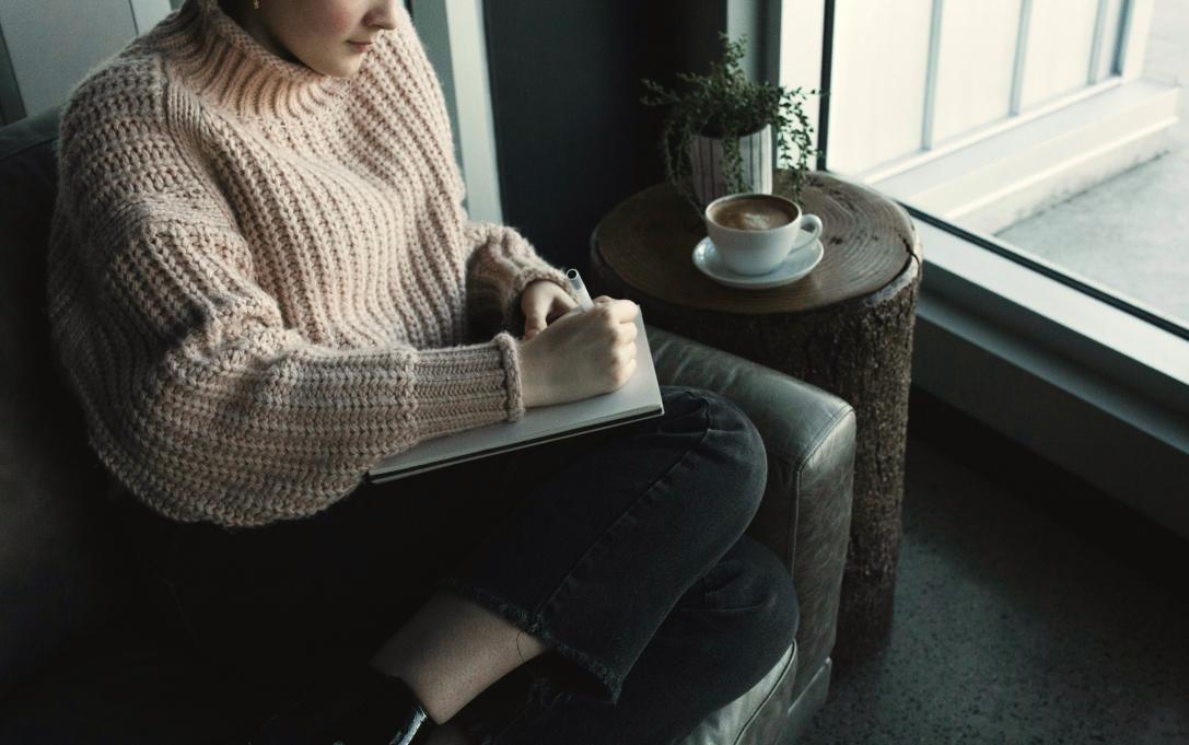 woman writing on a notepad