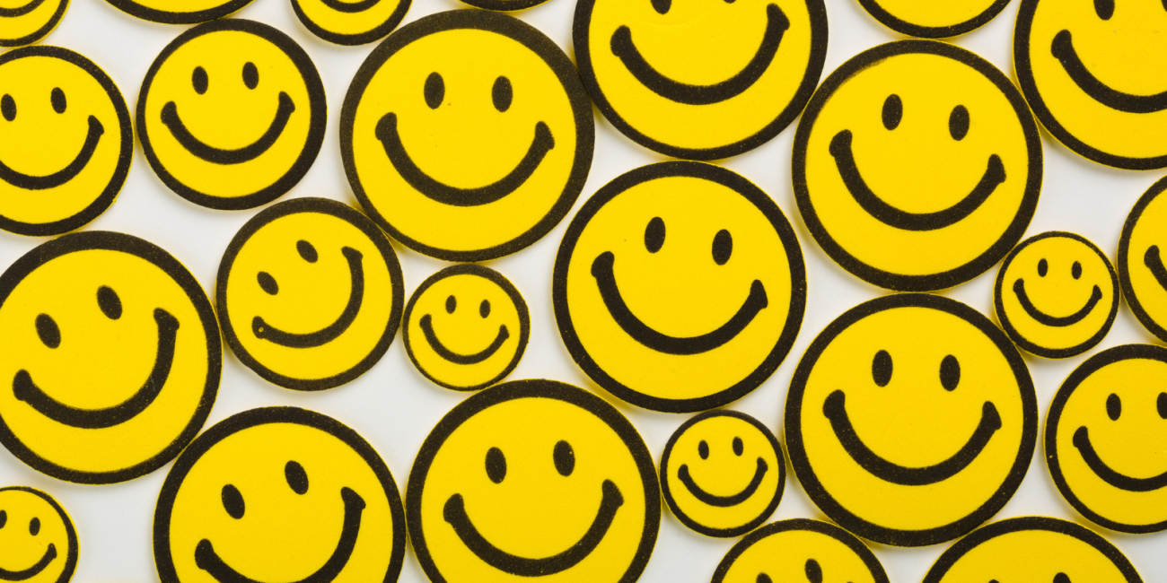 many yellow smiley faces on a white background