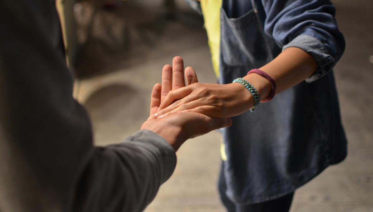 two people lightly holding hands
