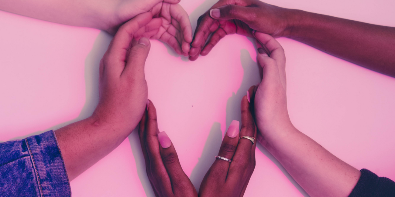 a group of hands forming the shape of a heart on a pink background