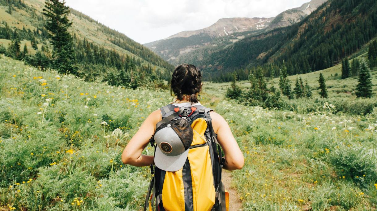 a young woman hiking through a valley