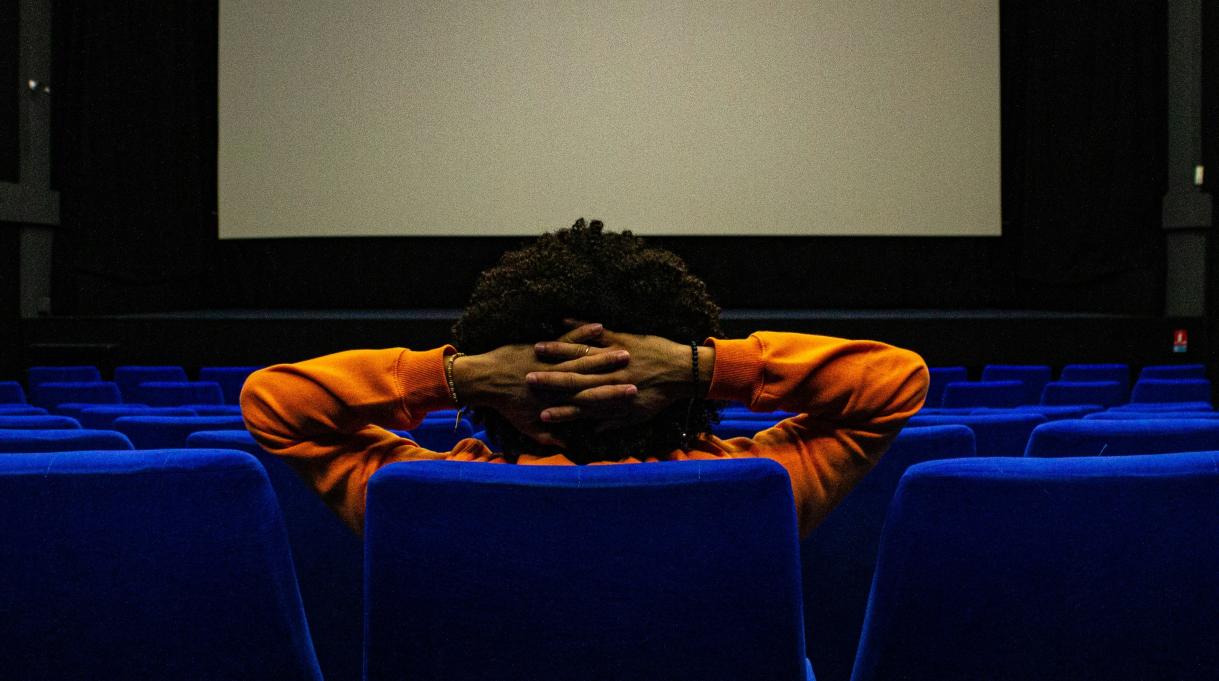 person sitting in the movie theater alone