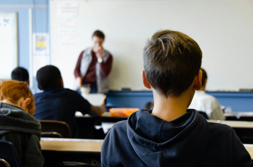 Classroom full of kids facing the teacher at the front