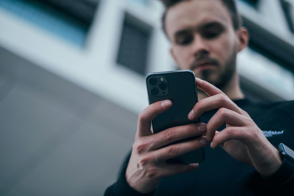 A man looking down at a smartphone. 