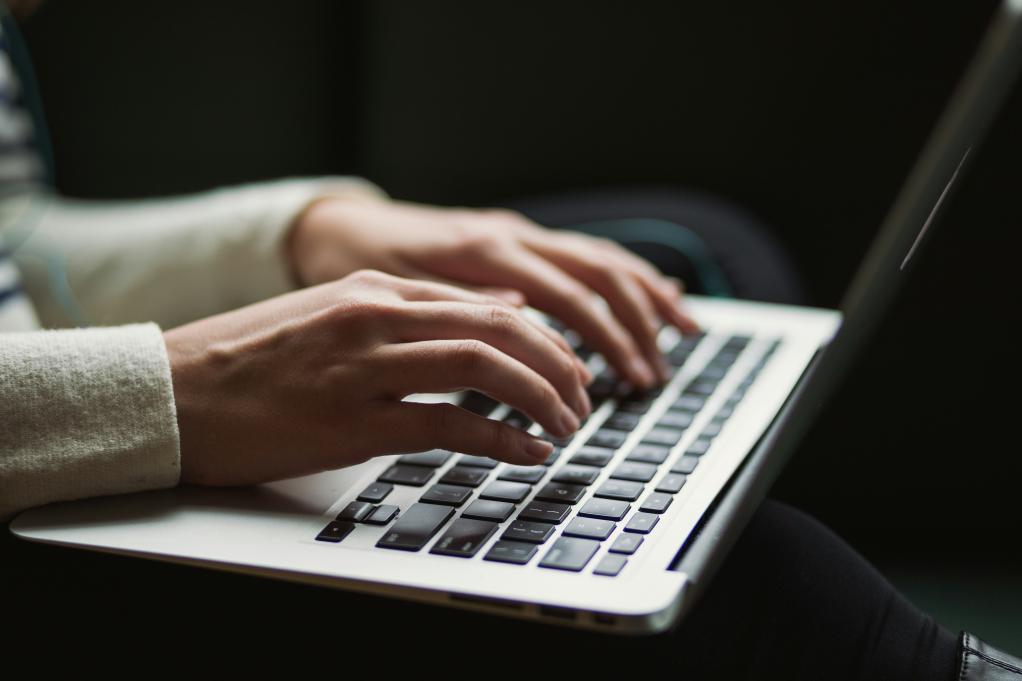 A cropped image of someone typing on a computer.