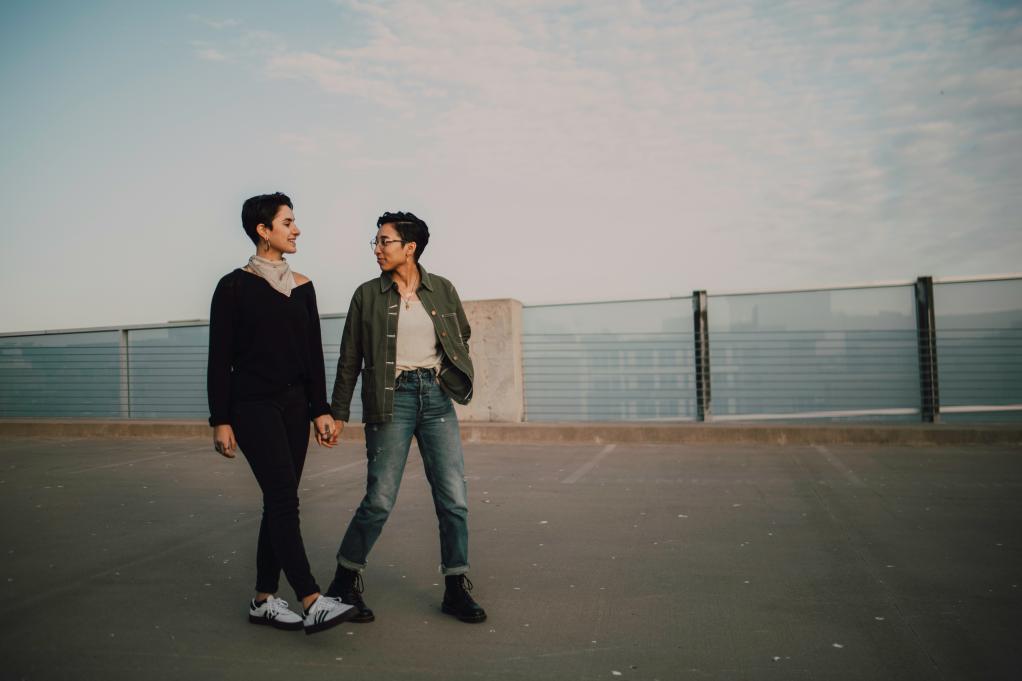 Two queer people holding hands. 