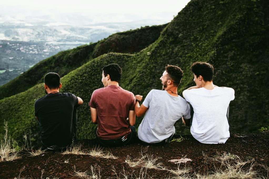 Four boys looking out over a mountain.