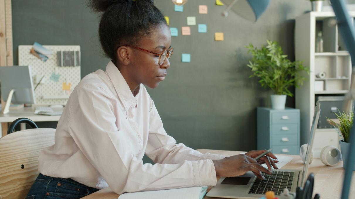 A black woman working at a computer. 