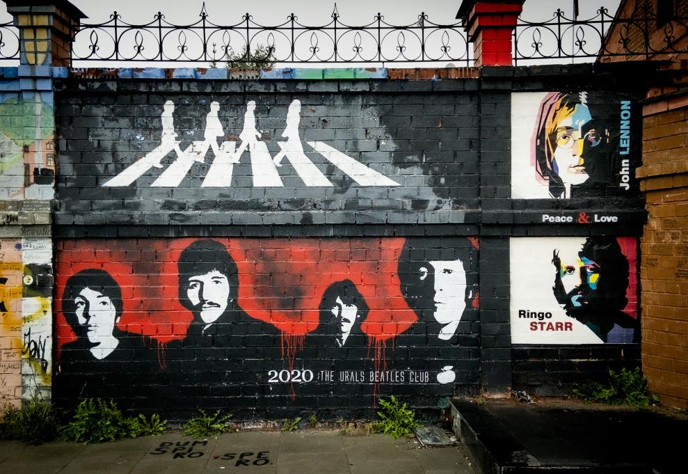 A photograph of a Beatles mural. The top half shows the Beatles on Abbey Road and the bottom half displays their faces.