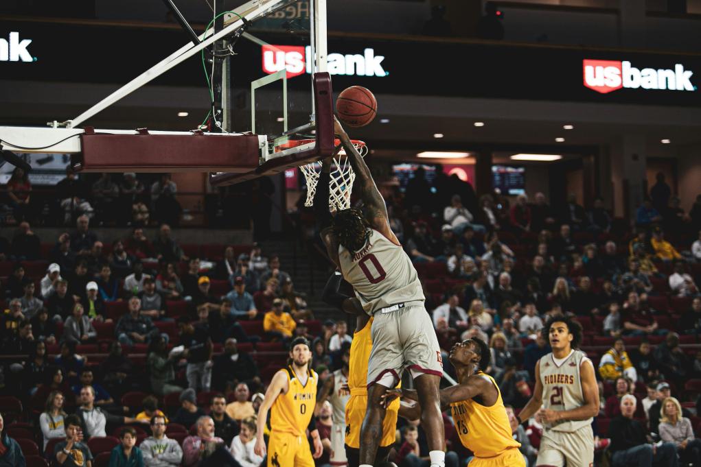 An American team basketball player shoots in a full stadium. 