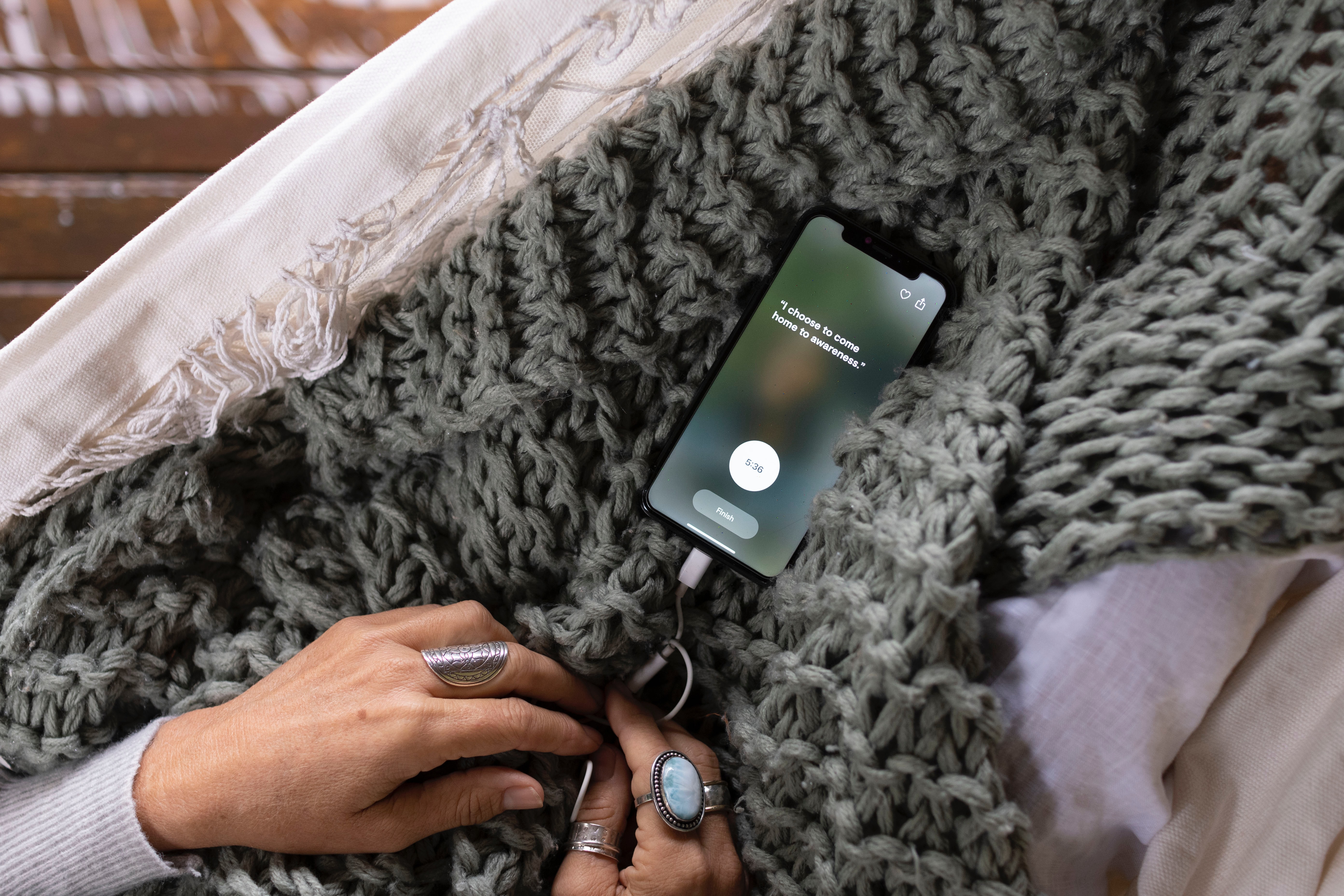 a phone displaying a mindfulness app on top of a blanket