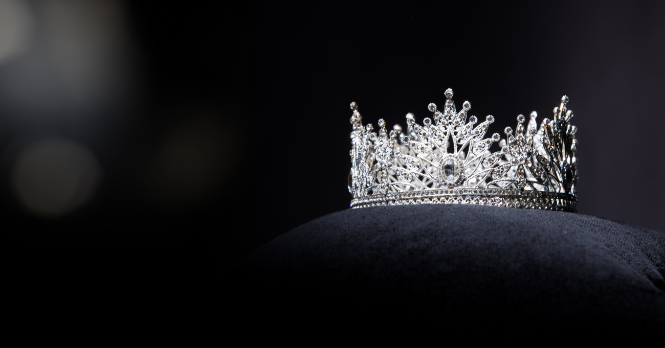 a white crown sitting on a pillow on a black background