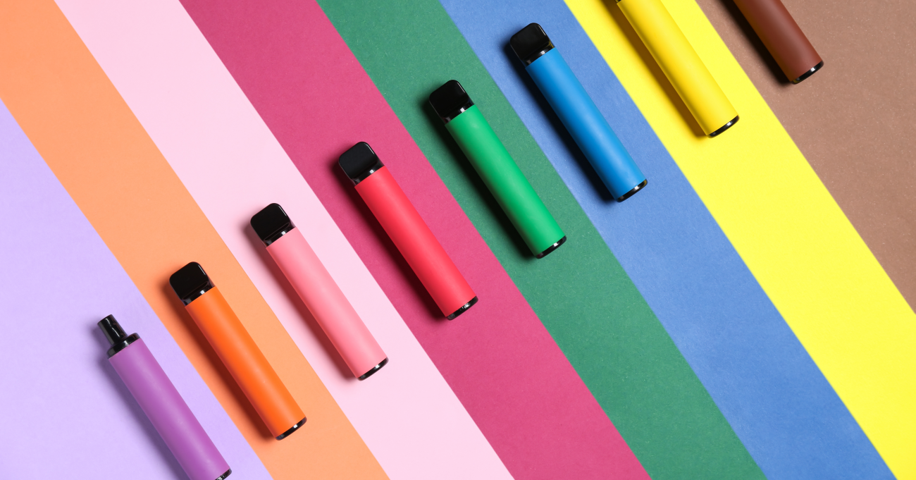vapes in assorted colors lined up on a colorful background