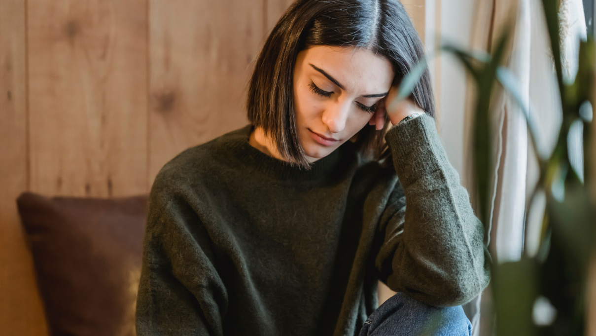 Sleepy woman resting her head on her hand with her eyes closed