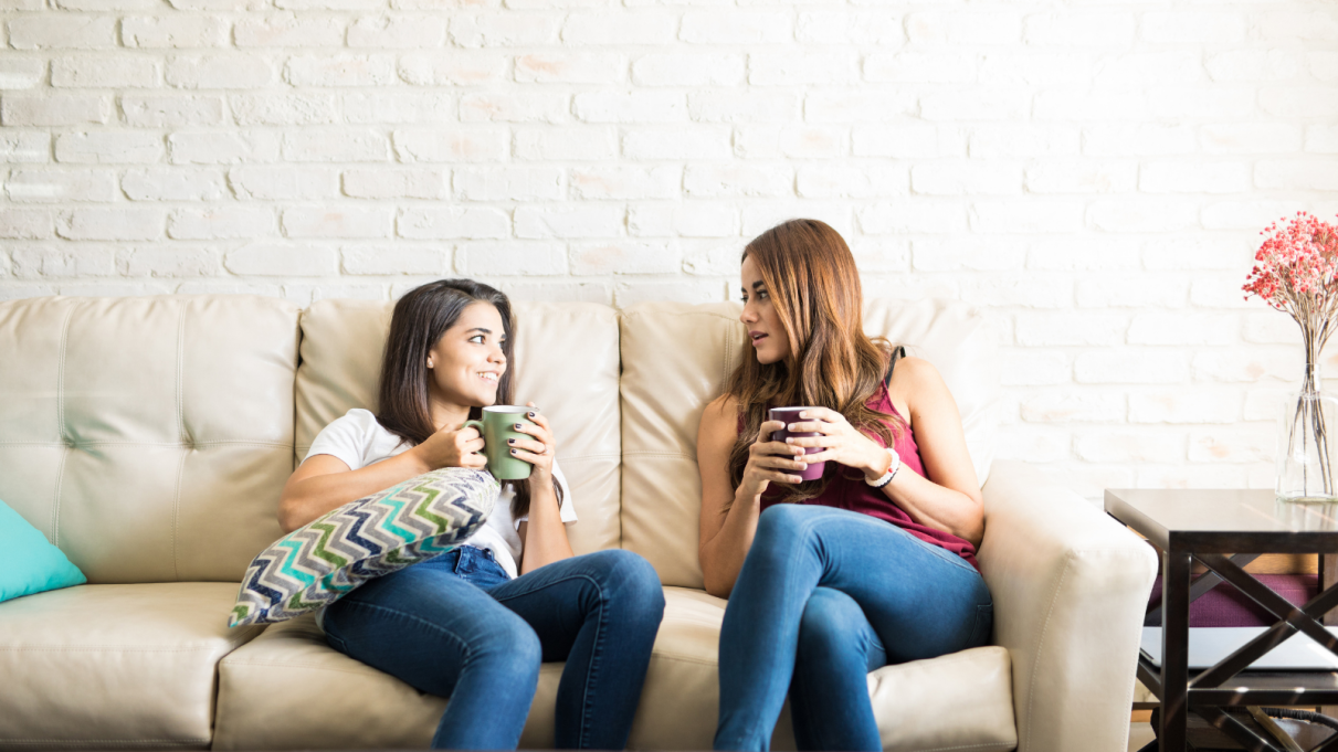 Two girls sitting on a couch talking